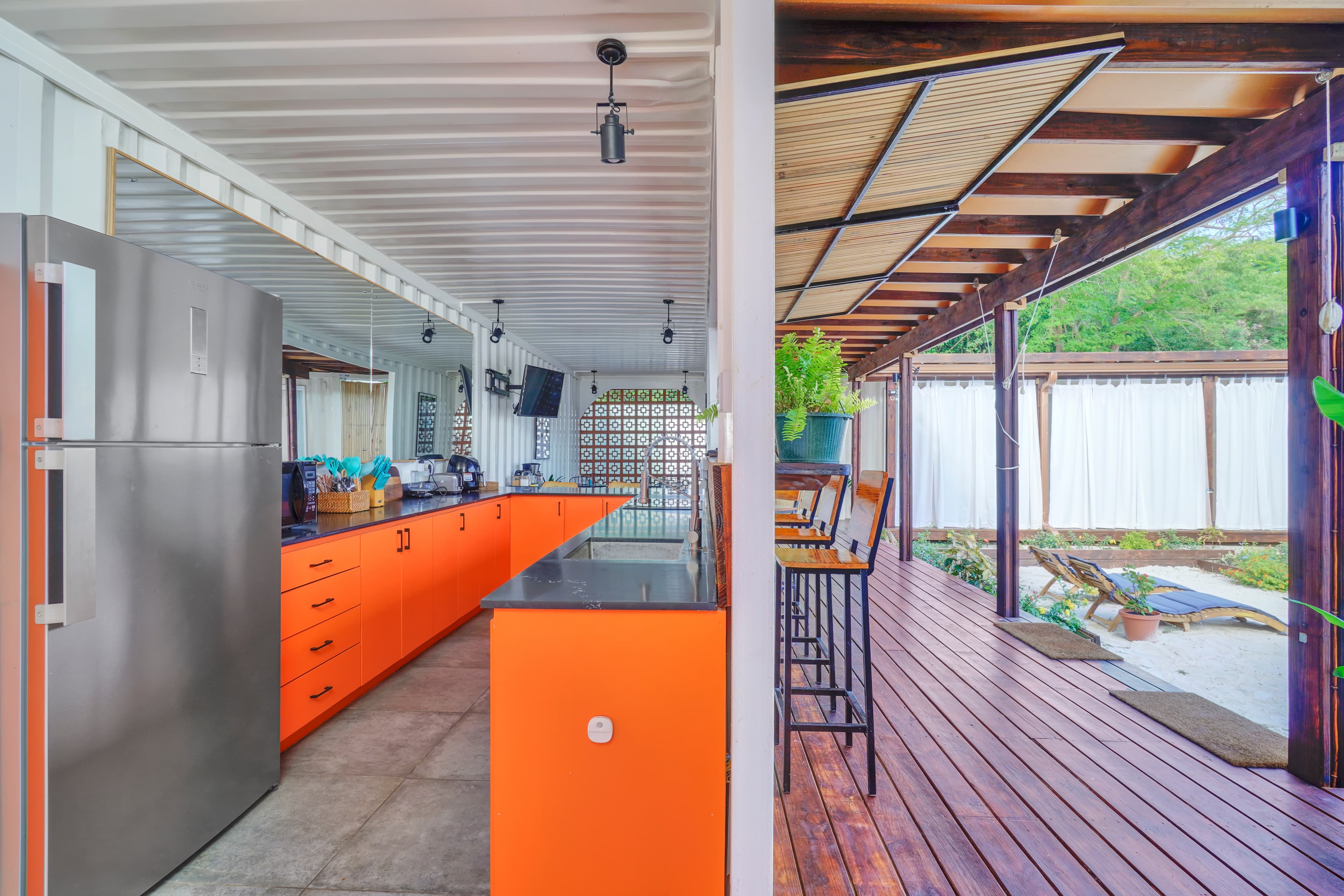 Open-plan kitchen and living area at Corten Villa with views of the pool and garden