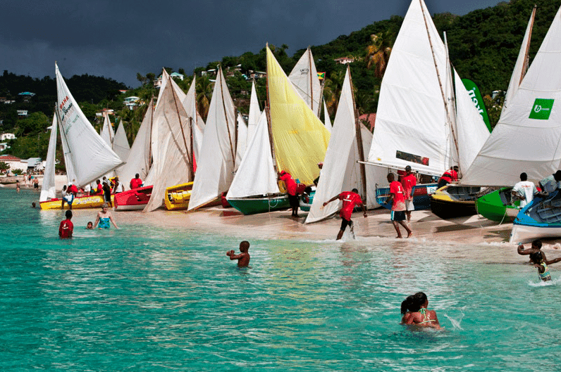 Traditional workboats with colorful sails at Grenada Sailing Week regatta